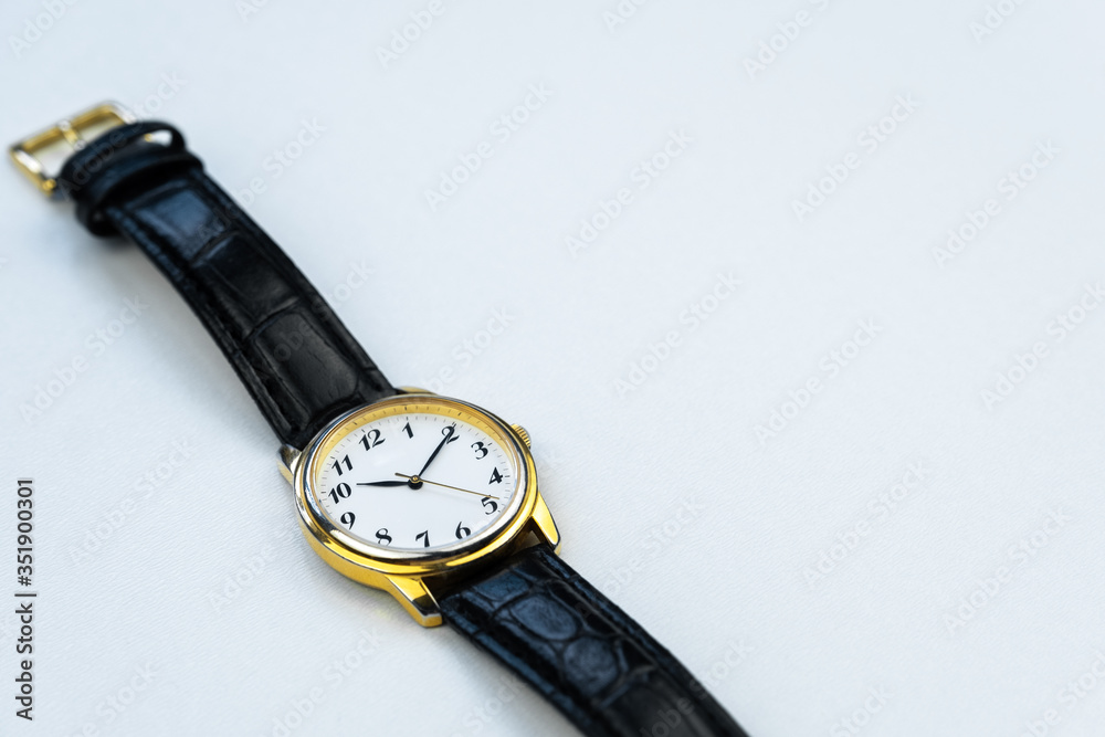 Retro golden wristwatch with Roman numerals isolated on white background close up. Retro golden wristwatch with Roman numerals isolated on white background close up.