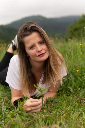 una chica guapa tumbada en un prado verde