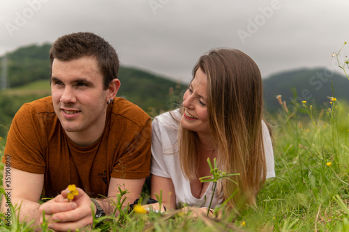 una pareja de jóvenes tumbados en un prado