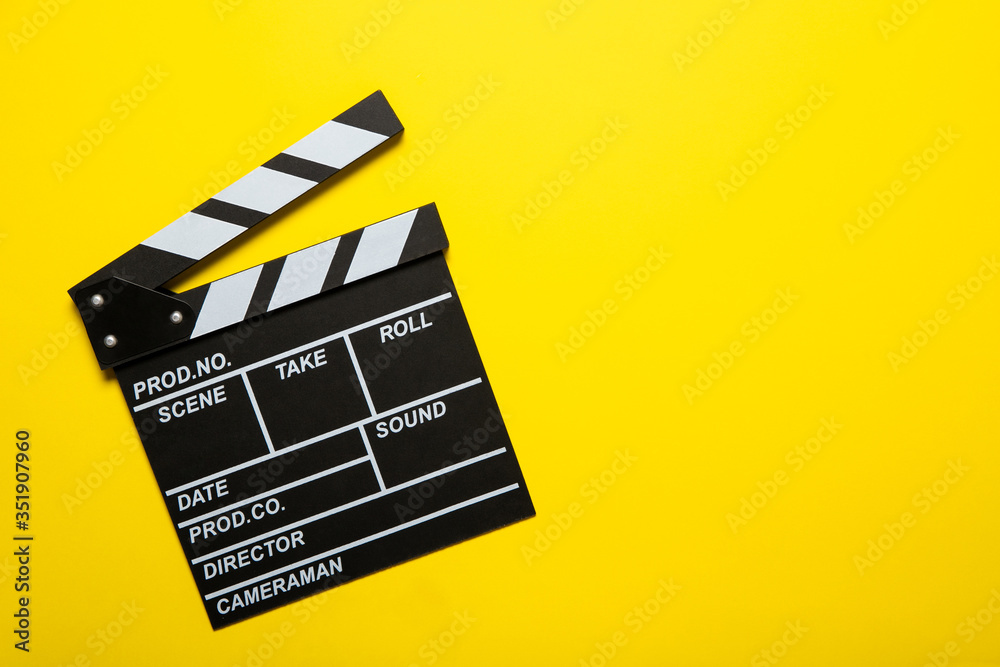 Movie clapper on a yellow background, top view. Place for text