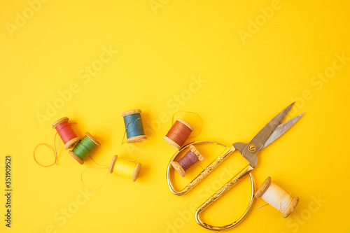 Colored coils with threads on a yellow background.Handicrafts and sewing.