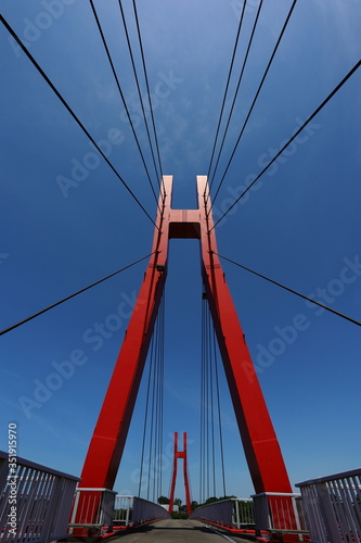 赤い支柱と放射状に延びるワイヤー © HIDEKAZU