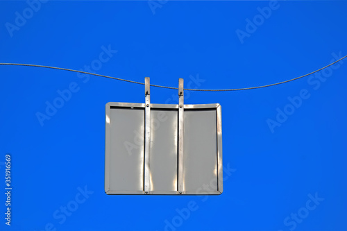 empty back side silver road sign on twisted metal wire on blue sky, security travel diversity