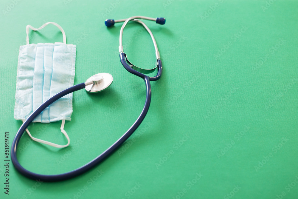 medical mask and stethoscope on green background medical mask and stethoscope on green background