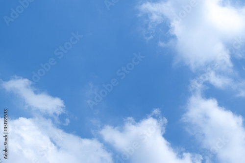 Group of white fluffy clouds and blue sky with copy free space middle for text.
