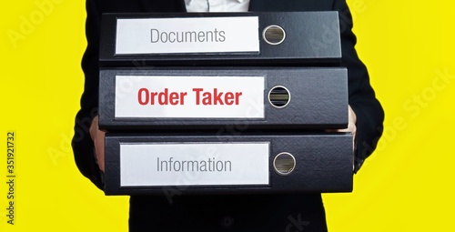 Order Taker. Businessman is carrying a stack of 3 file folders. Yellow background. Documents with word on label. Economy, Statistics, Finance photo