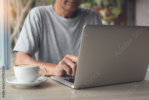 Casual business man surfing the internet on laptop computer online working from home