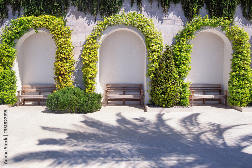 Fototapeta premium Park benches on embankment on sunny spring day. Place to relax. Montenegro, Tivat city