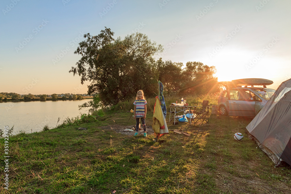 Camp with a tent and a car near the Volga River opposite village of