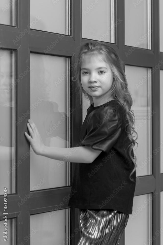 Little girl posing in studio near a large panoramic window