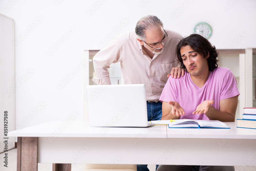 Old father helping his son in exam preparation
