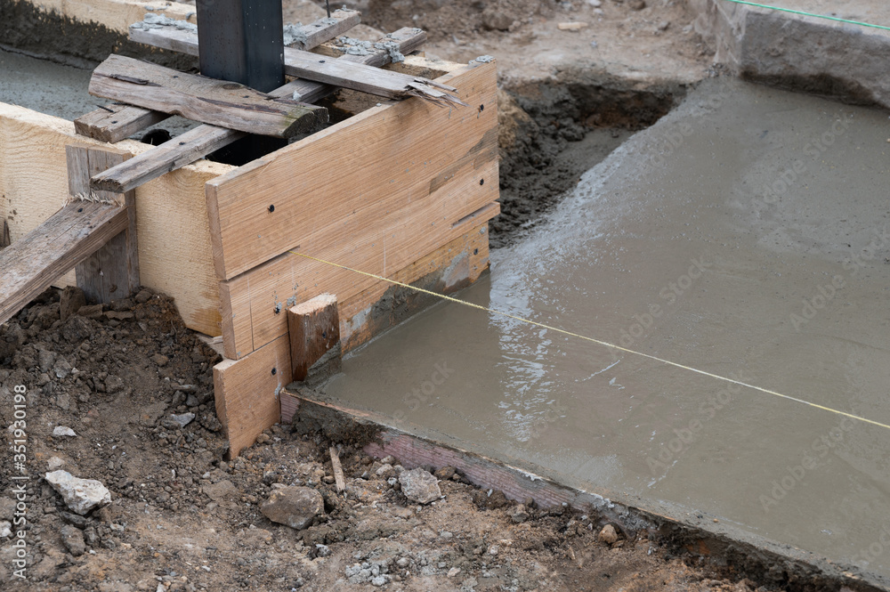 Pouring concrete into formwork for new fence Pouring concrete into formwork for new fence