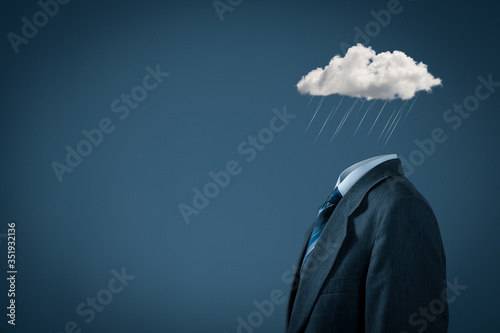 Businessman feels blue in crisis (bad and hard) times. Sad and depressed feels, mood and emotion represented by color and cloud with rain instead of the head. photo