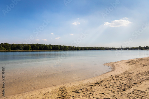 Wallpaper Mural A lake and beach in the Netherlands used for recreation, swimming and sunbathing in Brabant. Calm water, greenery, sand and a blue sky. Relaxation Torontodigital.ca