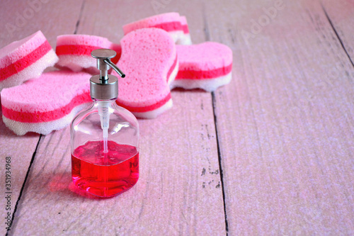 washing dishes , tools for cleaning kitchen dishes  and appliances , dispenser with red dish soap and pink sponge