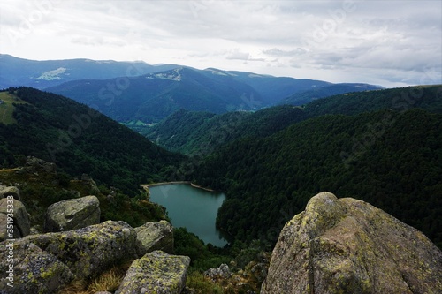 View on lake Schiessrothried with big rocks and hilly landscape of the Vosges