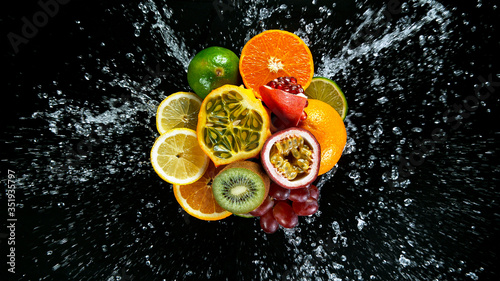 Super Slow Motion Shot of Fresh Fruits with Splashing Water Isolated on Black Background.