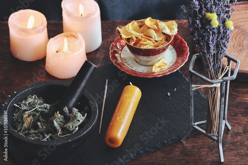 Canvas Print Symbols and sigils carved onto a yellow gold color candlestick, that is laying on a black surface