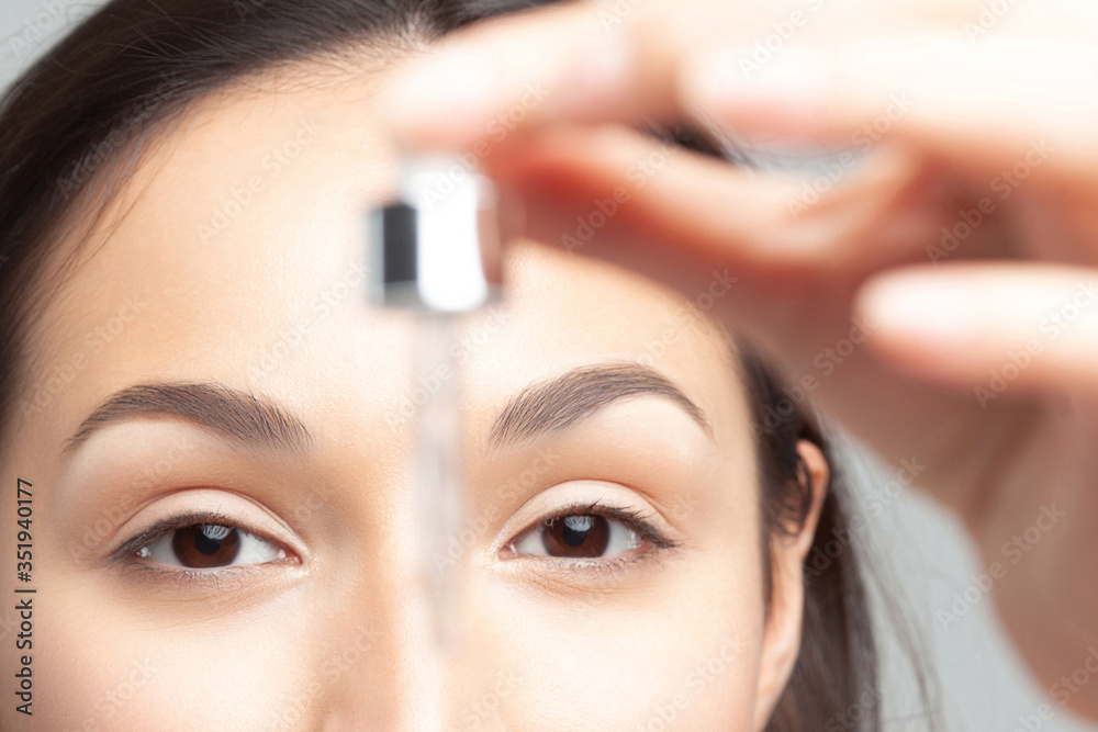 Young beautiful woman with pipette with clean perfect skin closeup Young beautiful woman with pipette with clean perfect skin closeup