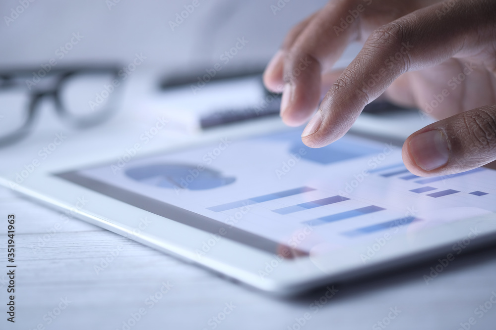 close up of man hand analyzing chart on digital tablet. 