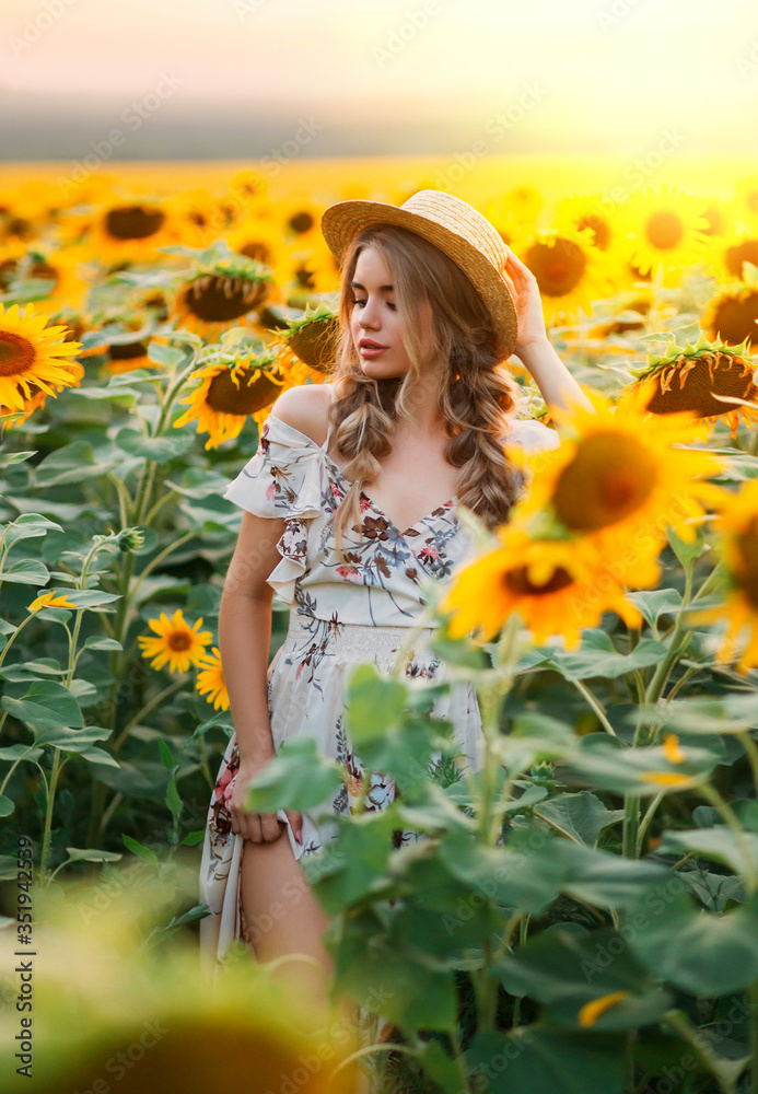 photo beauty woman model, blooming field. Rural fashion image. Yellow flowers sunflower. Blonde hair two braids, boater straw hat on head. Blurred backdrop bright sunny fantasy summer orange sunset photo beauty woman model, blooming field. Rural fashion image. Yellow flowers sunflower. Blonde hair two braids, boater straw hat on head. Blurred backdrop bright sunny fantasy summer orange sunset