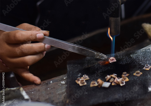 A person is melting silver to make jewellery. Craftsman at work