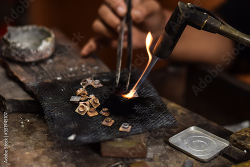 A person is melting silver to make jewellery. Craftsman at work photo