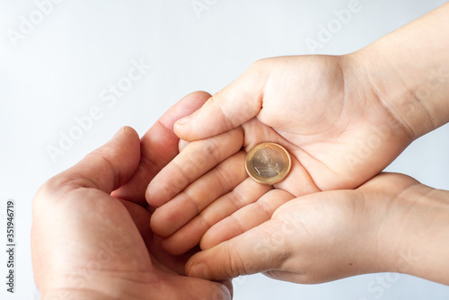 Obraz na płótnie Concept of donations, saving, or pocket money. Little child with coins and father hand, closeup. w salonie