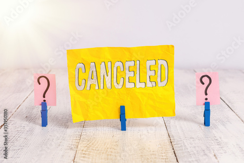 Writing note showing Canceled. Business concept for to decide not to conduct or perform something planned or expected Crumbling sheet with paper clips placed on the wooden table photo