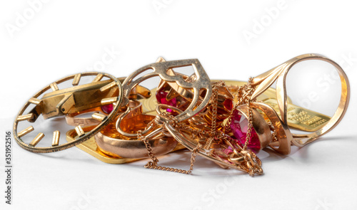 A scrap of gold. Old and broken jewelry, bars, watches of gold and gold-plated on a white background.