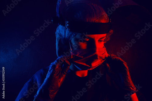 female doctor in medical mask on the face and gloves on a dark background