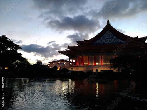 Illuminated Temple At Lake Against Sky During Sunset