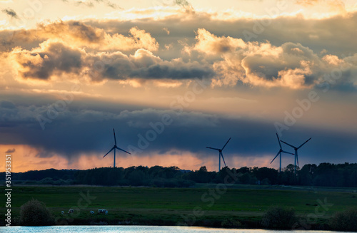 turbines and dranatic rainy sky at sunset photo