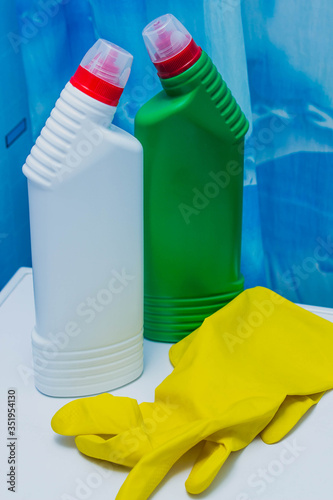 cleaning concept. Cleaning products and yellow gloves on a blue bathroom background.