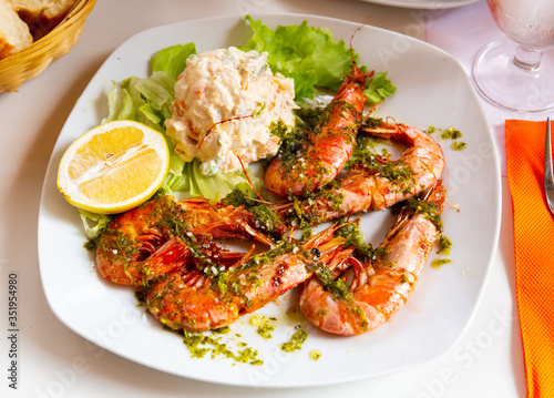 Delicious king shrimps and salad from potatoes at plate