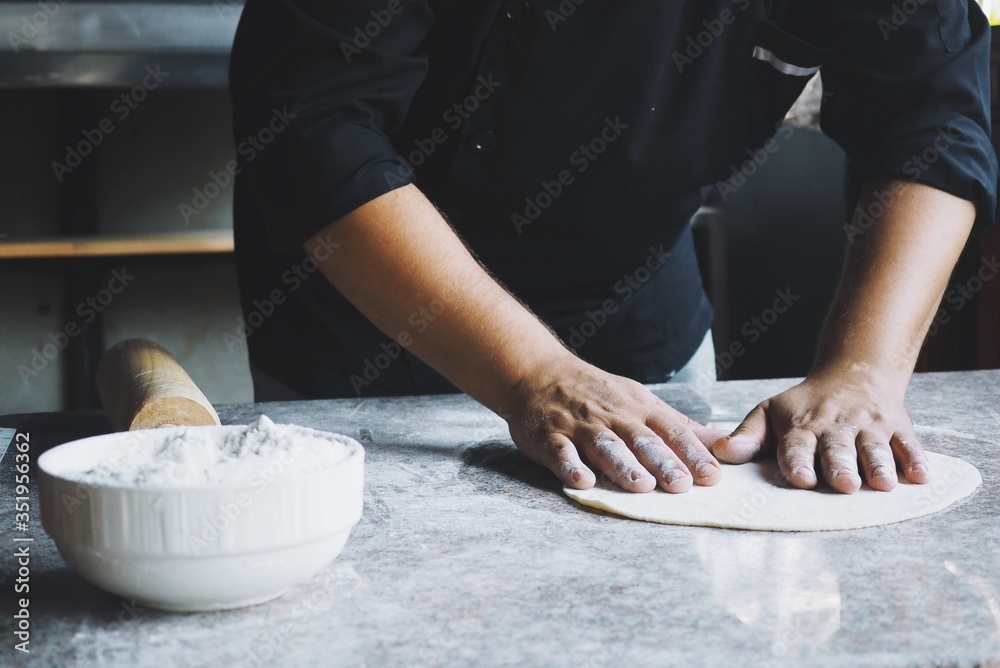 Close up pastry chef hands with dough and flour for making a pizza, bread, pasta.