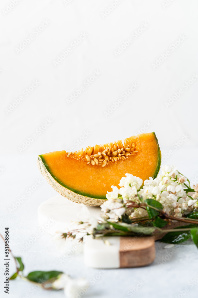 Fresh Cavaillon melon with white flowers on a white background. Fresh Cavaillon melon with white flowers on a white background.
