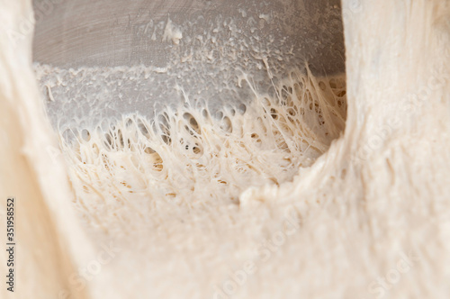 Stretching freshly homemade dough, showing threads
