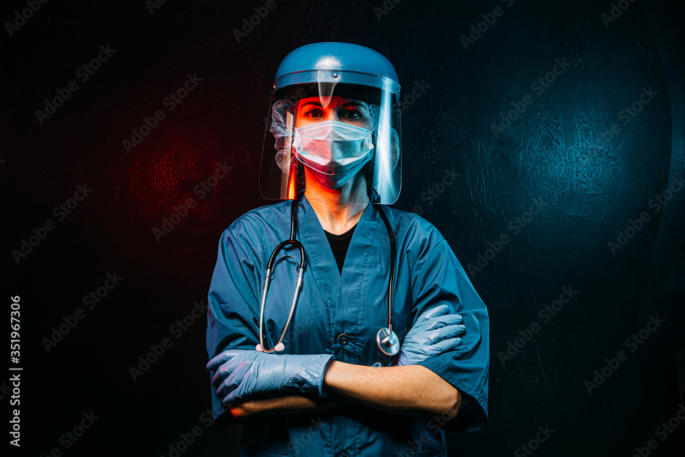 female doctor with a stethoscope on her neck, in a medical mask and glasses on her face on a dark background female doctor with a stethoscope on her neck, in a medical mask and glasses on her face on a dark background