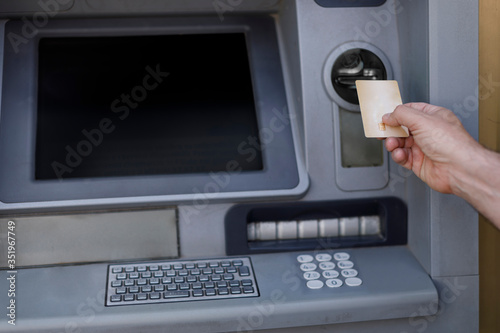 dettaglio delle mano del prelievo di denaro da un bancomat di una banca con una carta di credito. photo