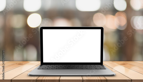 Laptop with blank screen on wooden table