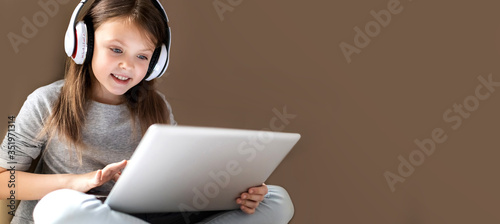 Kids distance learning. Cute clever little girl using laptop at home. Education, online study, home studying, schoolgirl children lifestyle concept. Horisontal banner. Copy space for text.