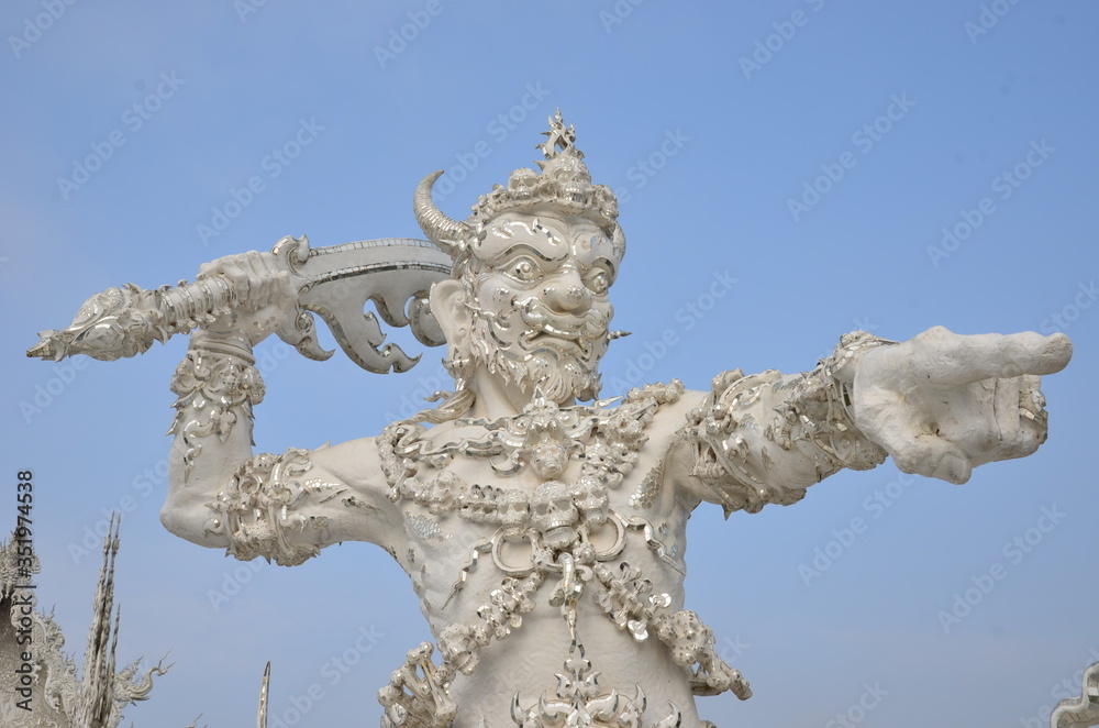 An angry demon is thowing his weapon at Wat Rong Khun, the beautiful white temple in Chiang Rai