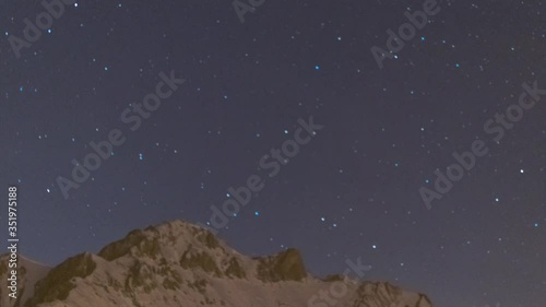 Mountains with stars passing by time lapse