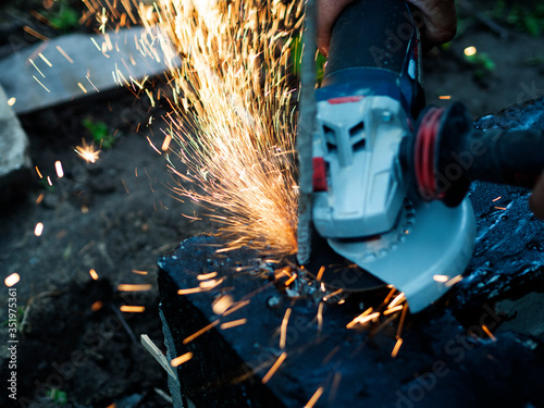Worker cuts off excess reinforcement in the foundation using an angle grinder