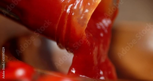 Tomato sauce poured from the glass jar.