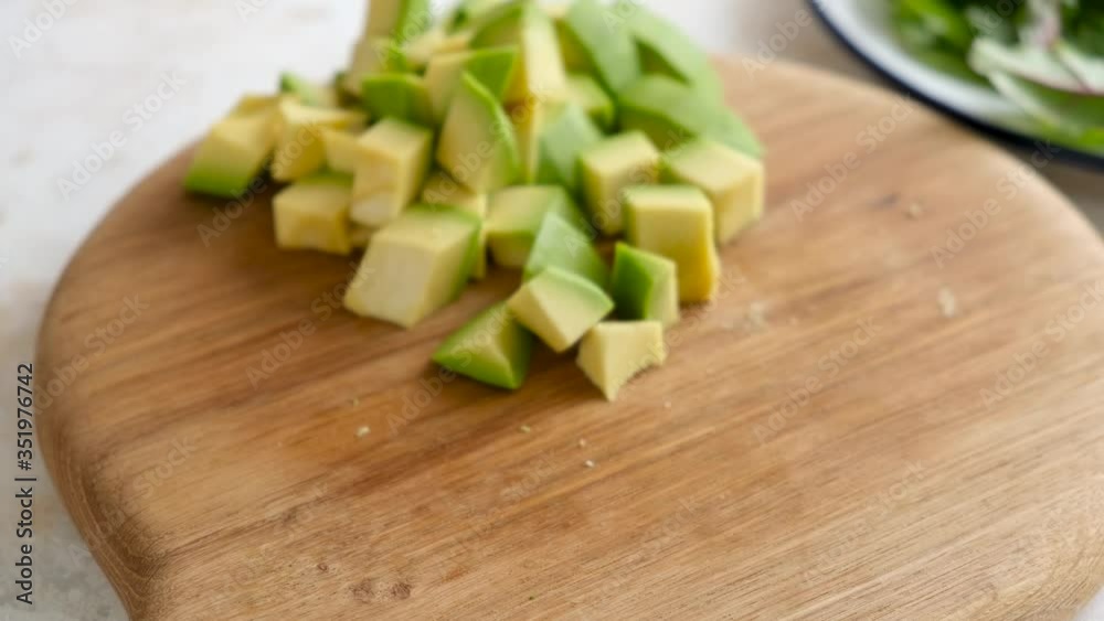 Avocado cut in cube chunks. Cooking healhy food. Hand picks chopped avocado Avocado cut in cube chunks. Cooking healhy food. Hand picks chopped avocado