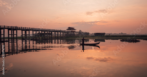Fisherman crosses a river around U-Bein Bridge  Myanmar  Burma