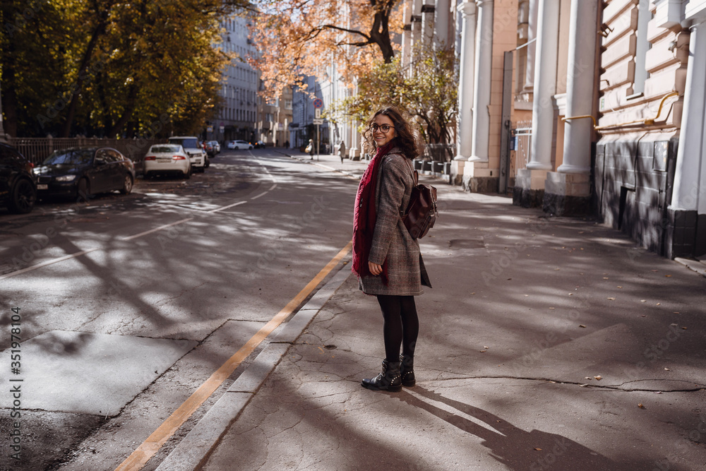 Portrait of beautiful brunette girl walking down the street.