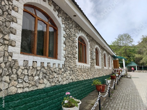 The stone building of an Orthodox monastery. Flowers, chains photo